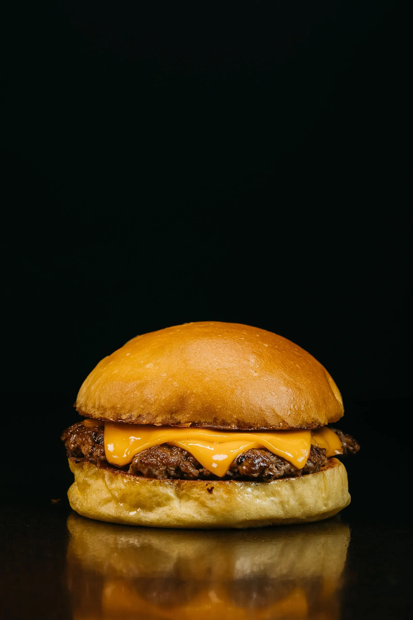 Cheeseburger dengan patty smash dan keju leleh di atas brioche