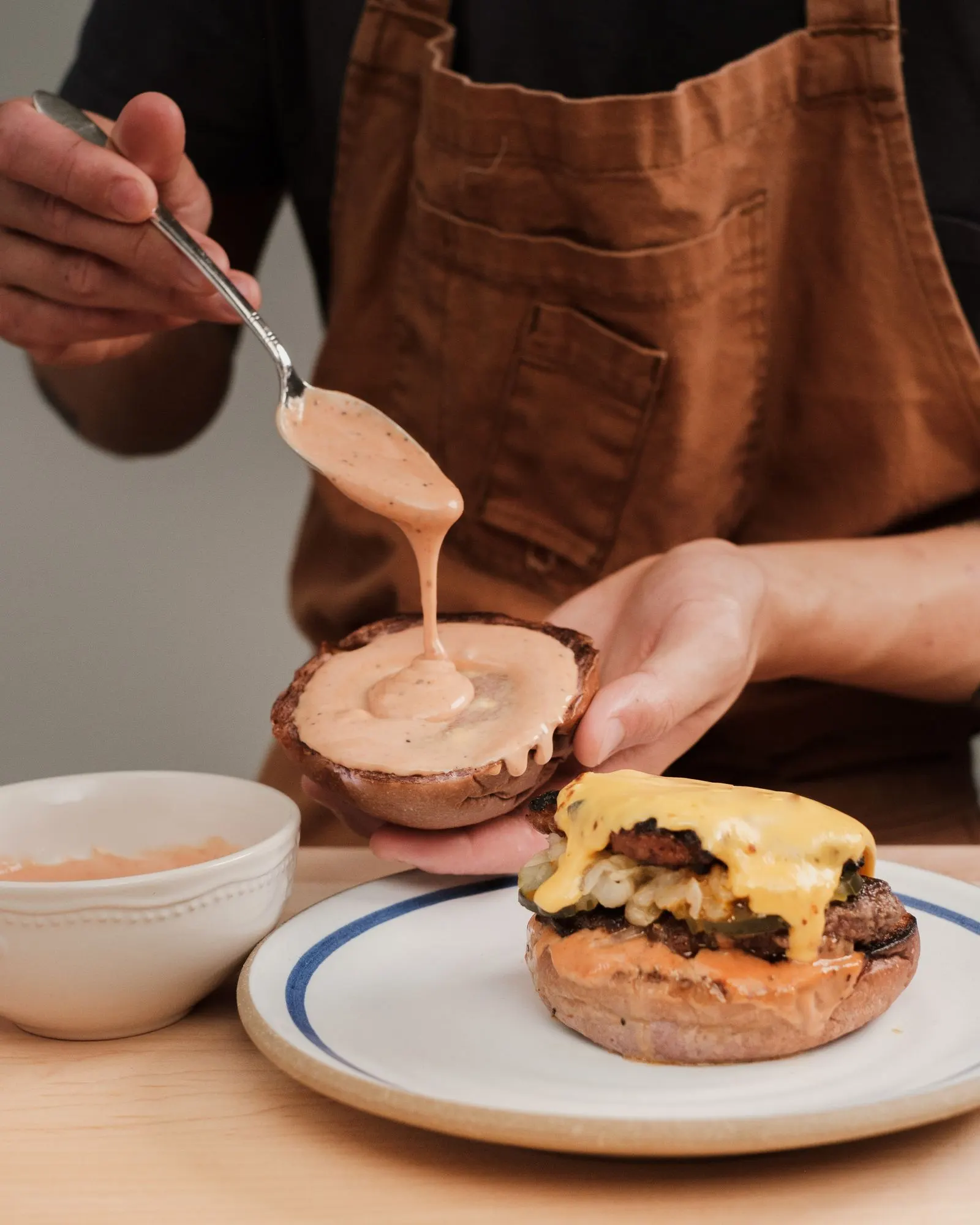Saus dioleskan ke atas roti burger